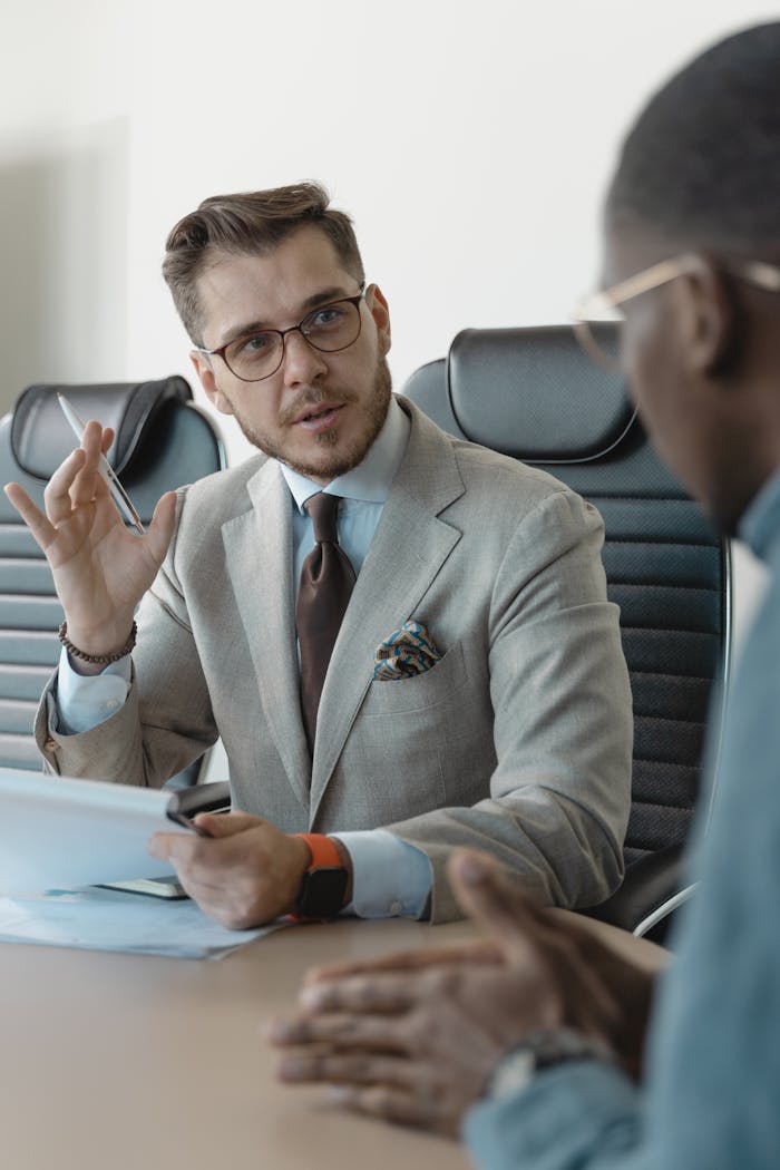 ROSARIUM CONSULTING Two businessmen engaged in a professional meeting in a modern office setting.
